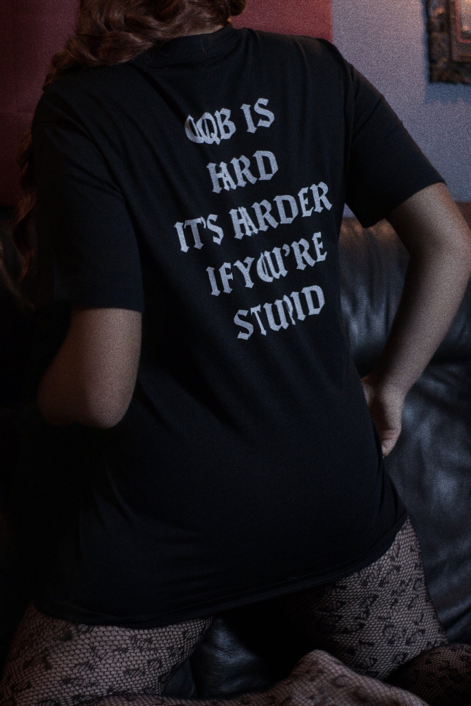 Rückansicht eines weiblichen Models, das das TIER1ONE Shirt mit dem Aufdruck "CQB is hard" trägt.