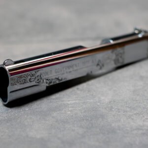 Detailaufnahme einer Lasergravur auf einem Colt 1911 Schlitten mit feinen Ornamenten auf verchromter Oberfläche